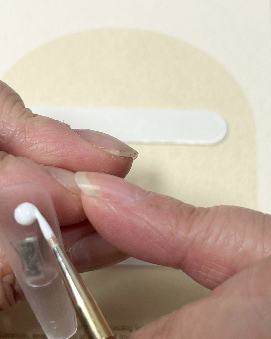 Un pennello liner che trascina il gel bianco dal punto centrale per creare laspetto a bocciolo di una rosa.