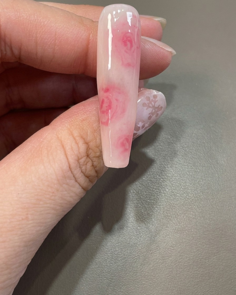 Un pennello riapplica uno strato di blooming gel trasparente sopra un design esistente.