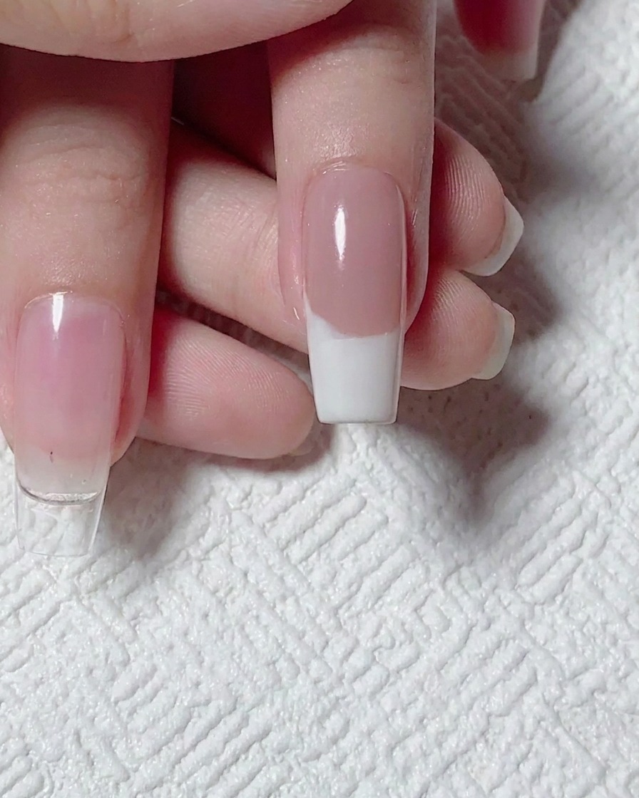 Vista dallalto di una French manicure bianca su base nude, pronta per la nail art.