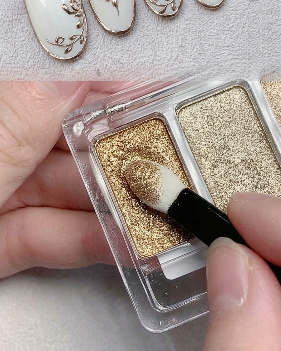 Un applicatore in spugna per ombretto che preleva polvere cromata oro metallizzata da una tavolozza.