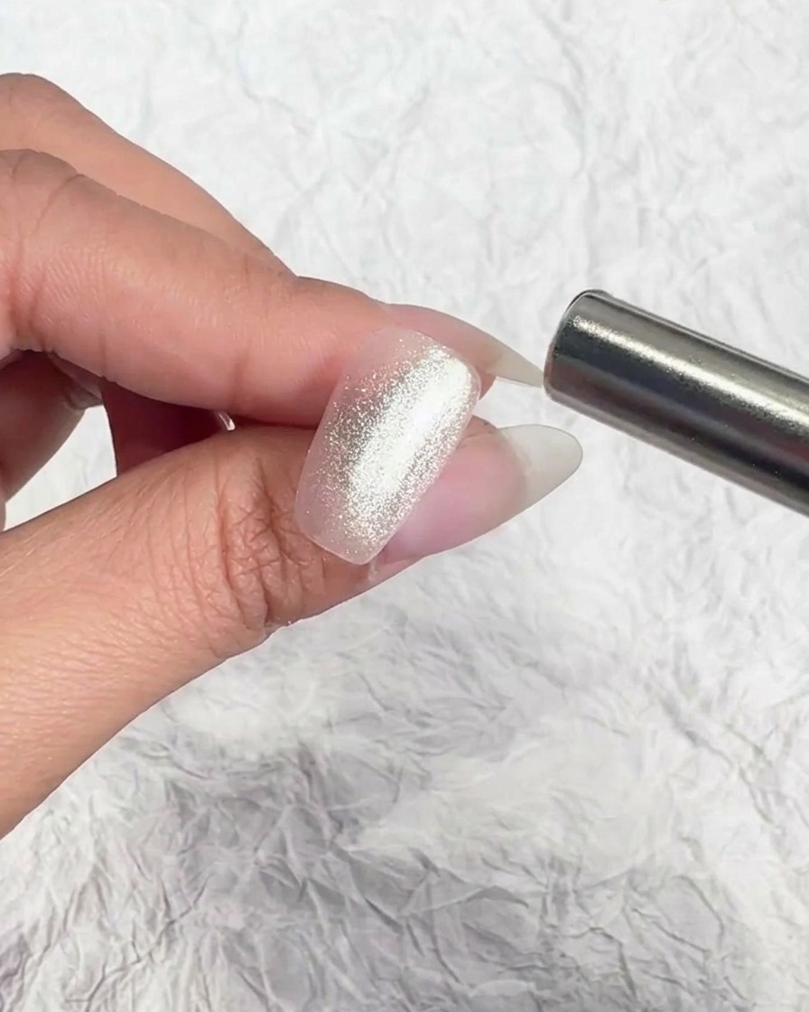 Uno strumento magnetico metallico tenuto vicino a ununghia per manipolare le particelle magnetiche.