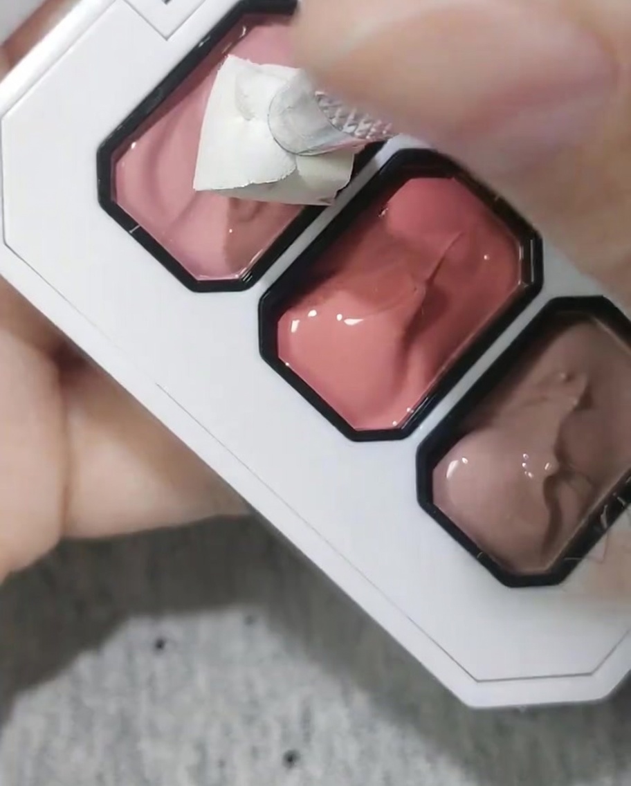 Spugna cosmetica utilizzata per picchiettare gel rosa sulla punta di ununghia.
