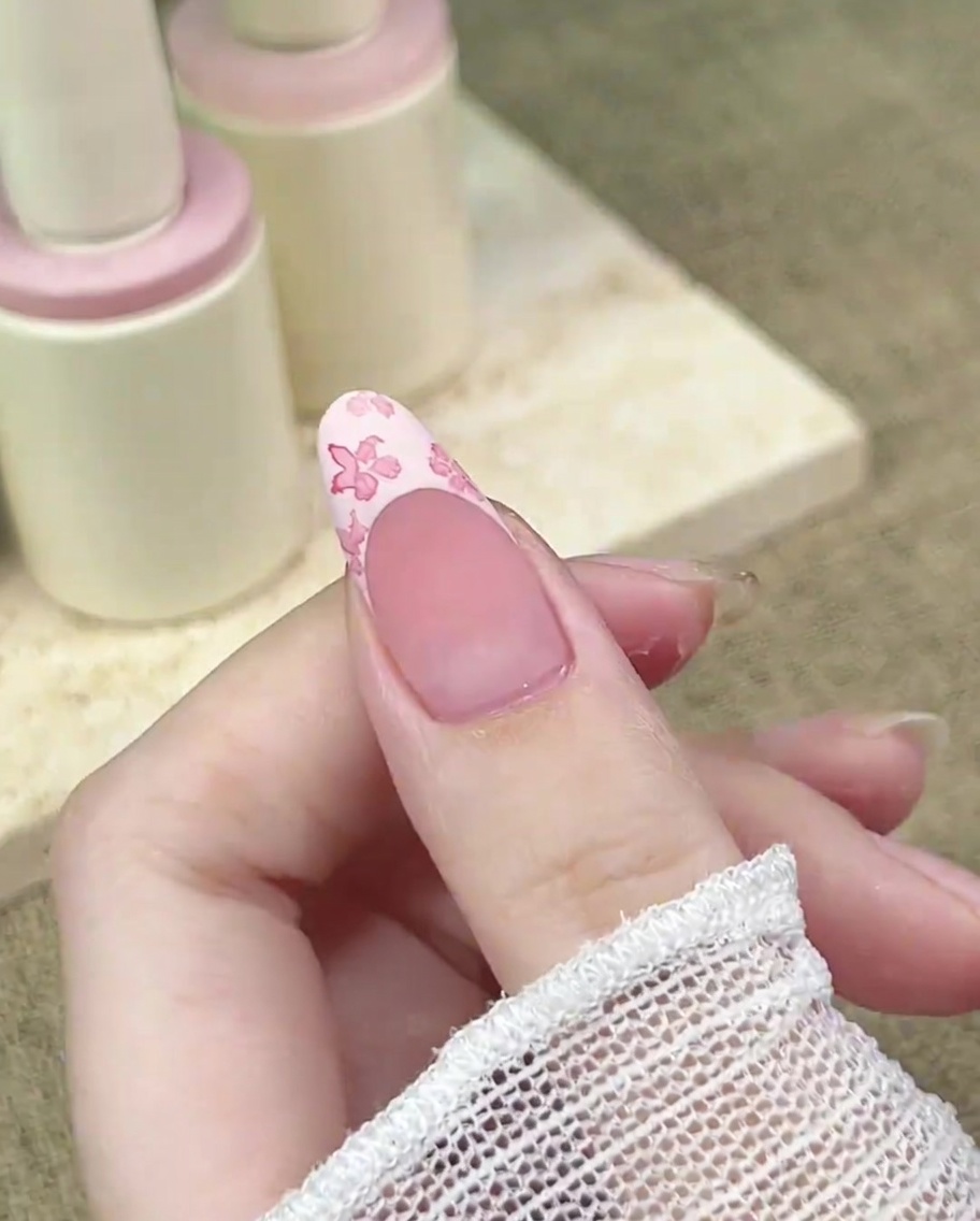 Primo piano di un pennello di precisione che aggiunge un punto concentrato di rosa scuro al centro di un fiore.
