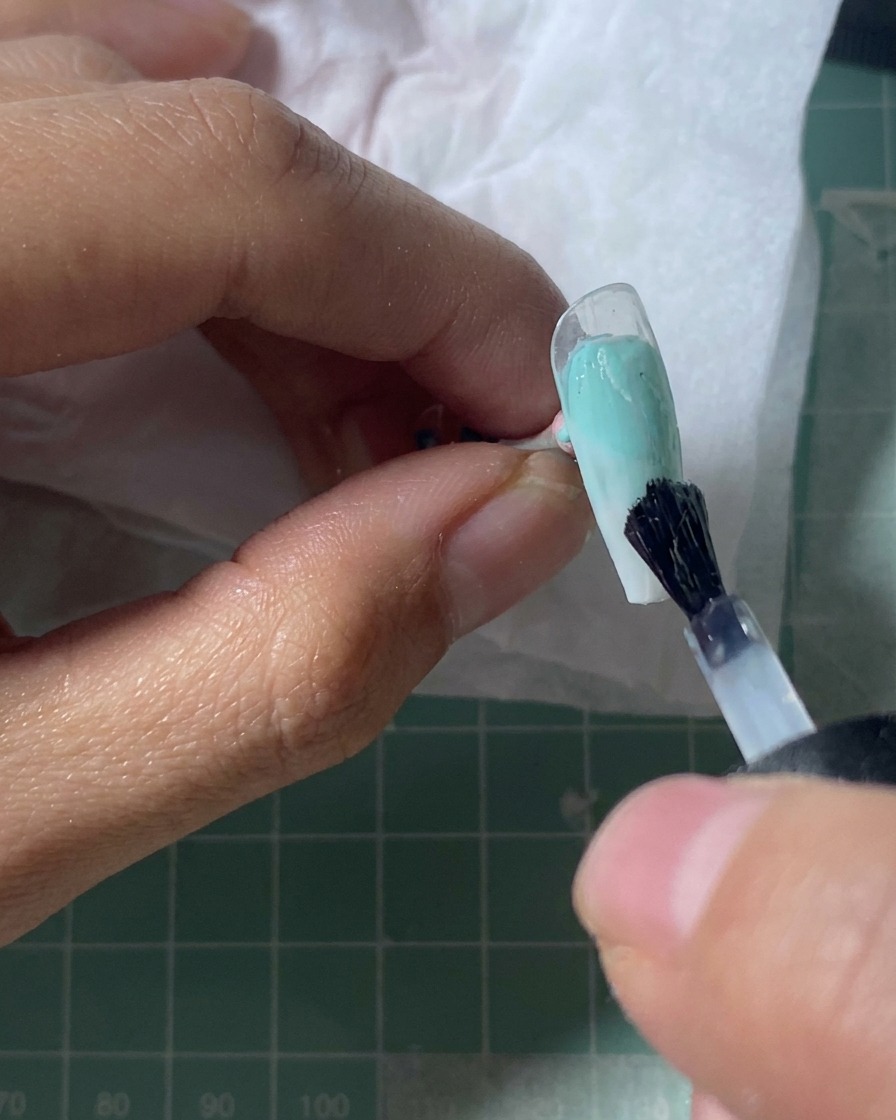 Una tip che riposa sotto una lampada UV, con la superficie che appare impostata e lucida.