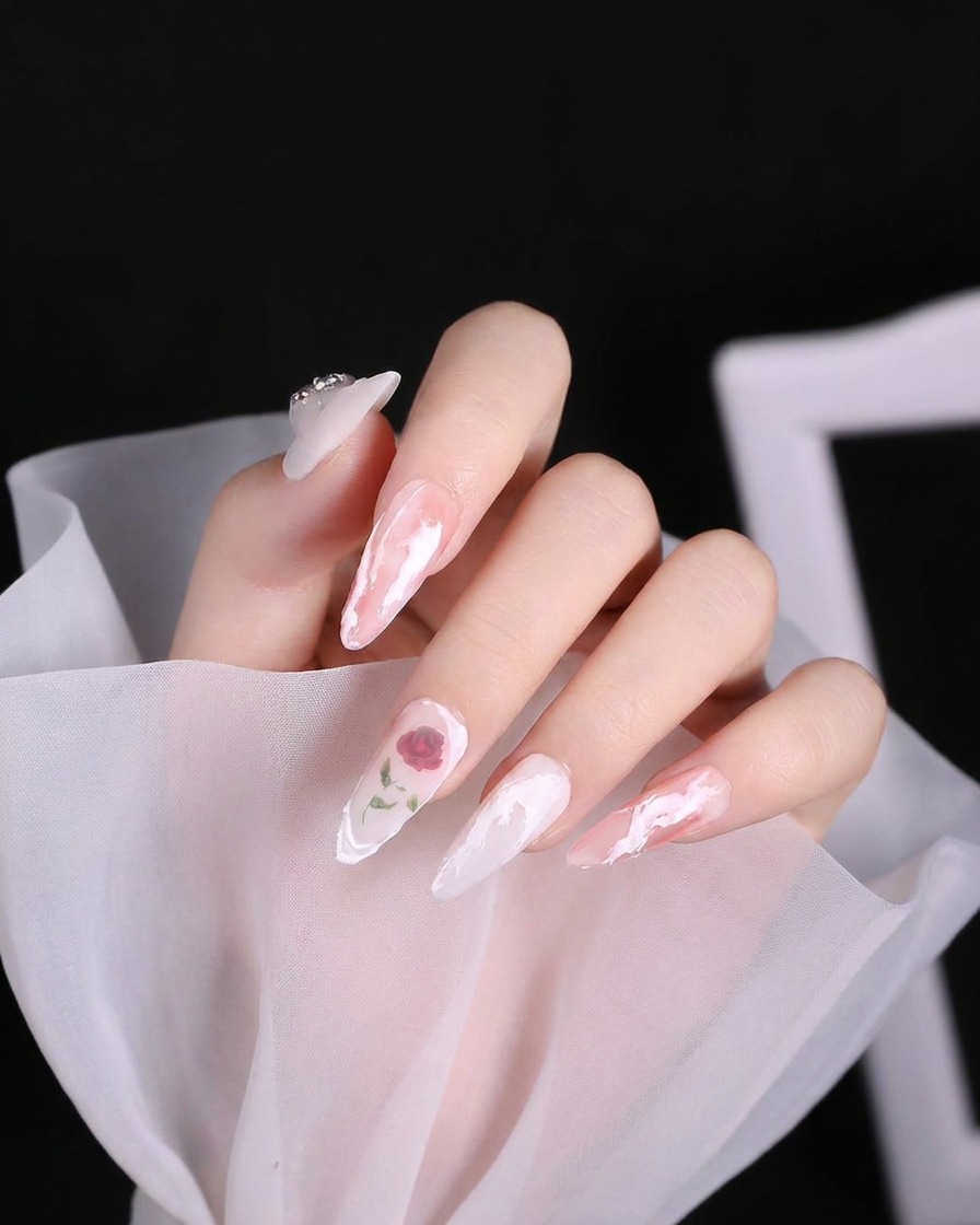 Un pennello per nail art che applica una spirale di gel bianco denso e testurizzato sullarea della cuticola di ununghia.