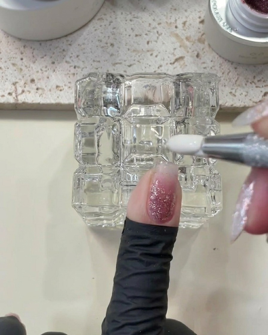 Un utensile in metallo utilizzato per rimuovere leccesso di gel attorno allarea della cuticola di ununghia.