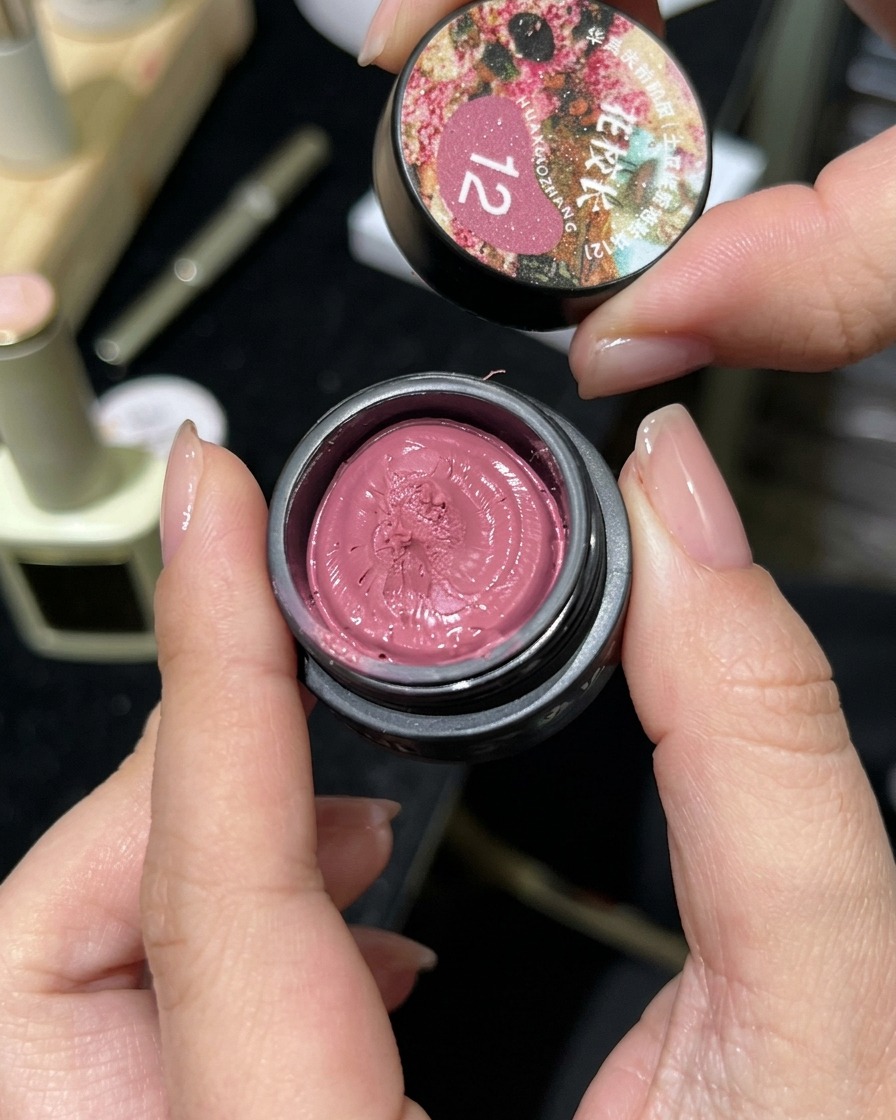 Un piccolo vasetto di gel magnetico cat-eye rosa aperto che mostra la sua consistenza simile allargilla.