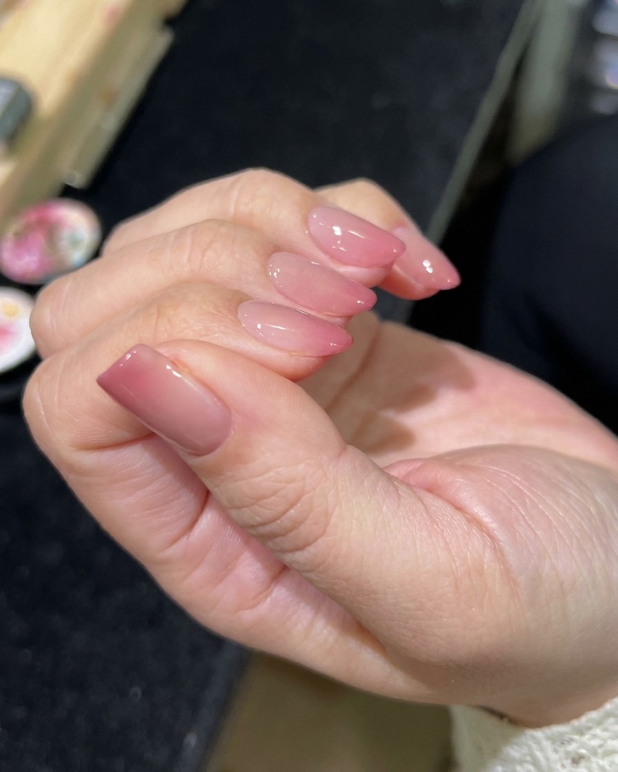 Un pennello che applica un top coat trasparente e lucido sopra la nail art magnetica finita.