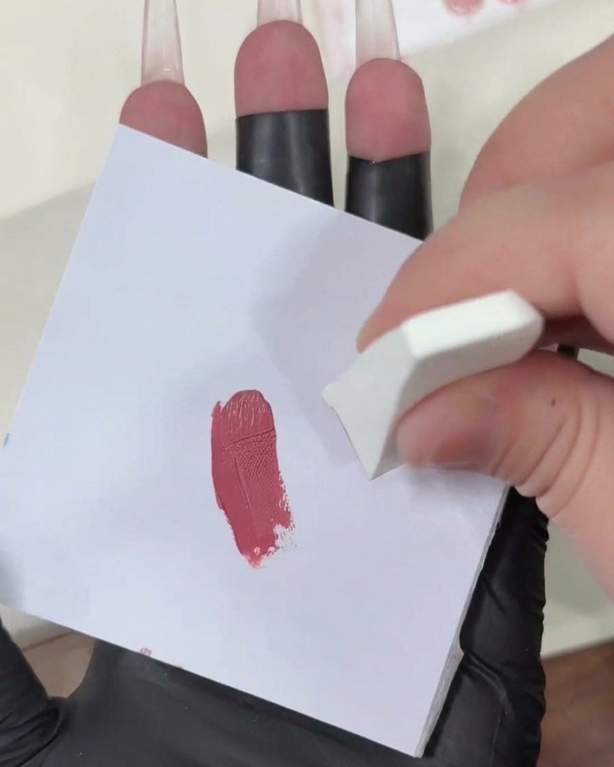 Picchiettare una spugnetta carica di gel su una superficie bianca pulita per diffondere il colore rosa.