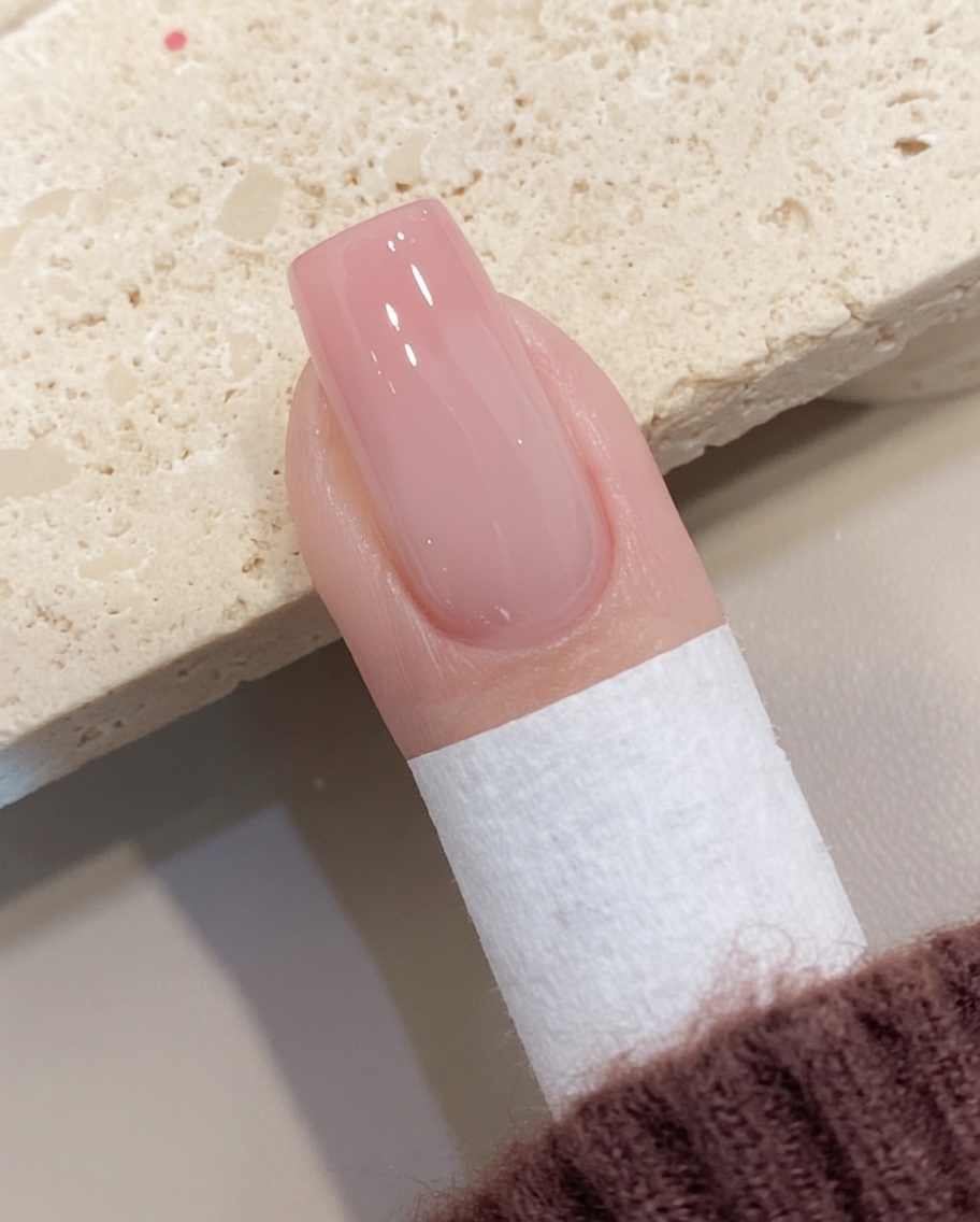 Un pad privo di lanugine rimuove lo strato appiccicoso dalla superficie di ununghia in gel polimerizzata.