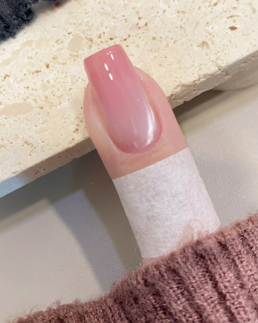 Una piccola quantità di gel color pesca applicata sul bordo libero dellunghia con un pennello.