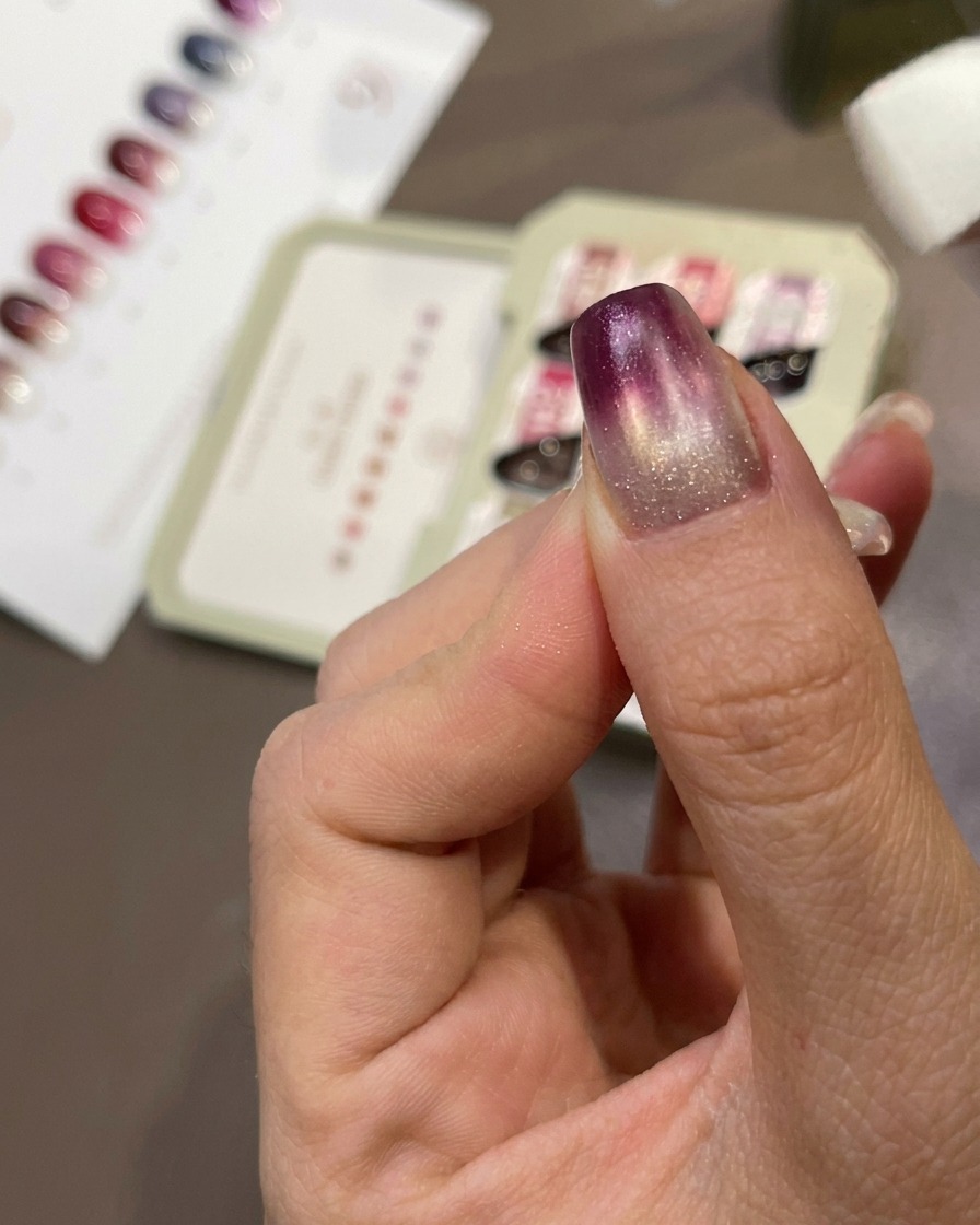 Una spugnetta che tampona il gel viola sullunghia per creare un effetto sfumato.