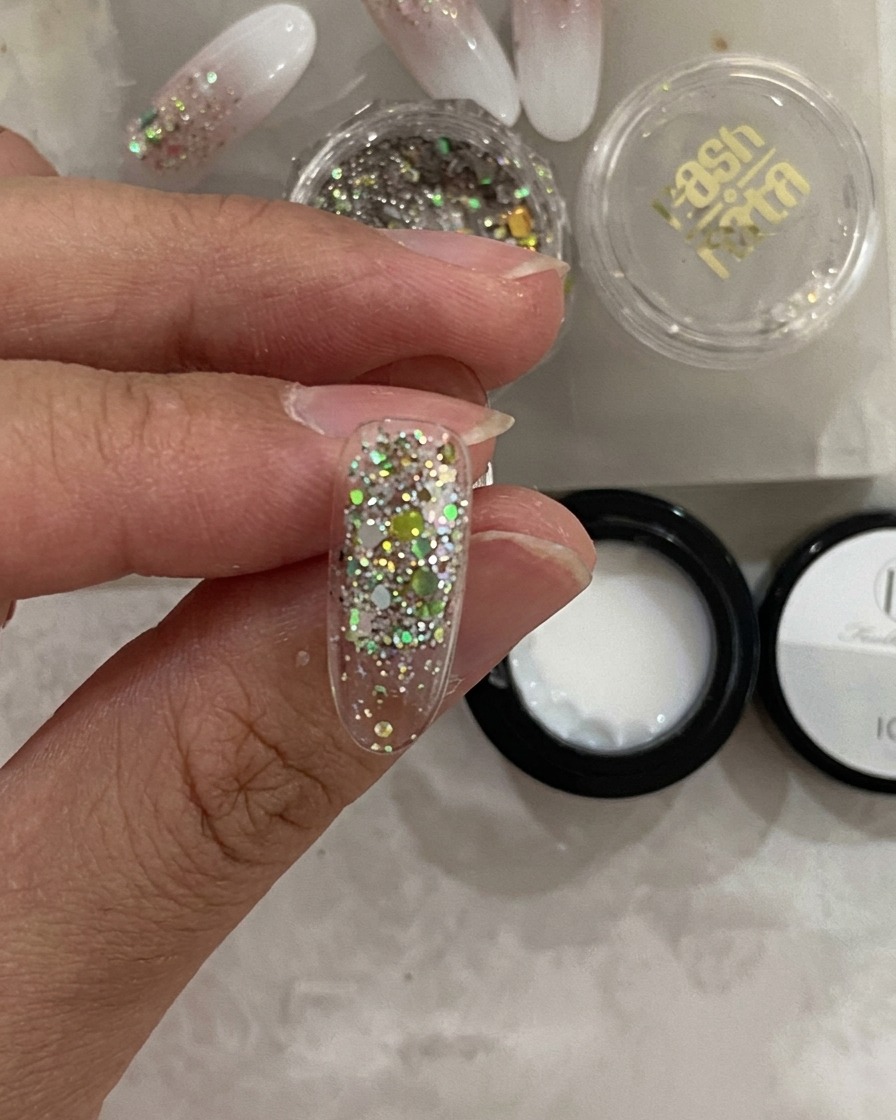 Primo piano di una tip allinterno di una lampada UV con lo strato di glitter che appare fissato.