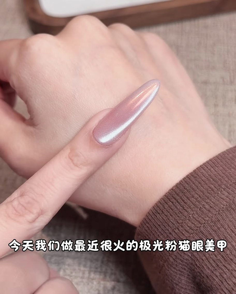 Una spugnetta da trucco applica pigmento rosa al centro di ununghia gel nude, creando una sfumatura soffusa.