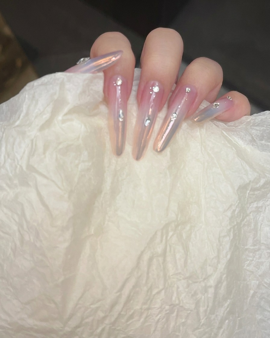 Unghie posizionate sotto una lampada UV/LED professionale per polimerizzare il top coat rinforzante.