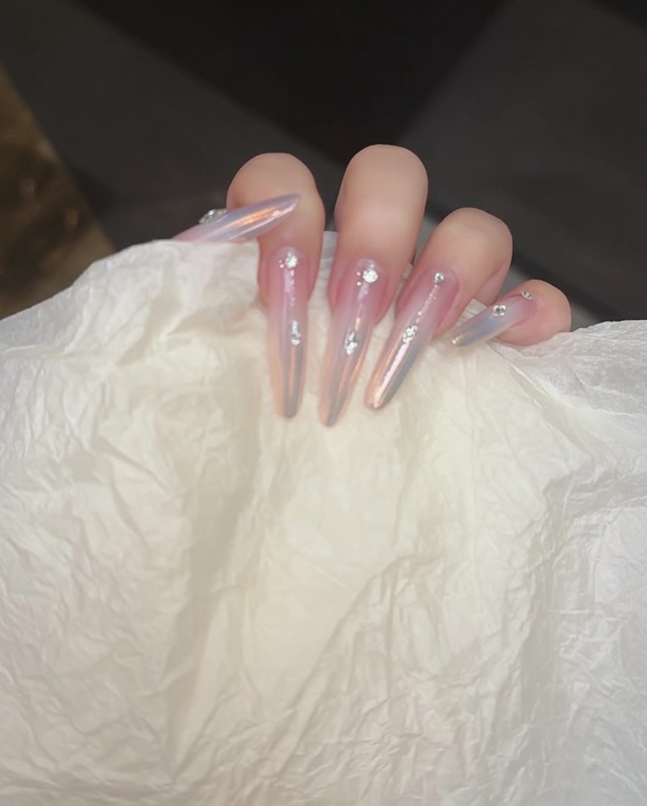 Applicazione di uno strato di hard gel trasparente sulla superficie dellunghia e sugli strass per sigillare il design finale.