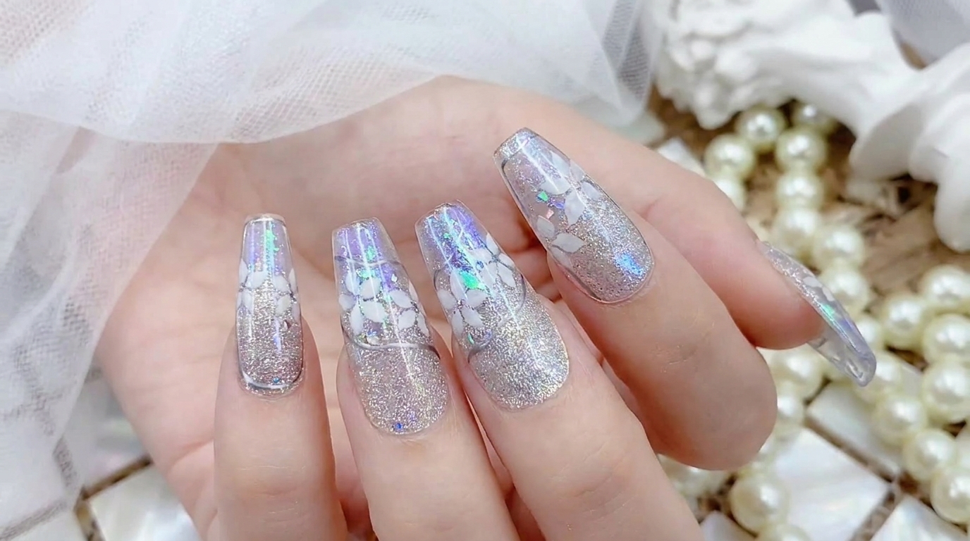 Splendide unghie press-on effetto aurora argento con dettagli floreali bianchi, glitter magnetici cat-eye e luminose scaglie di opale.