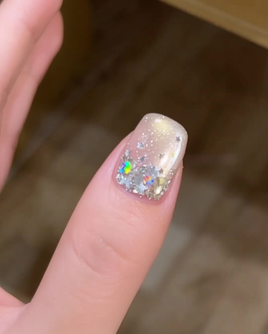 Primo piano di una mano con unghie decorate con stelle che riposano allinterno di una lampada UV.