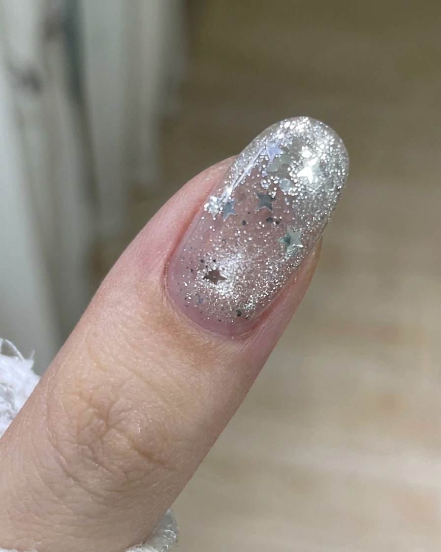 Una mano che rimuove delicatamente una striscia di vecchio smalto gel dalla superficie di ununghia.