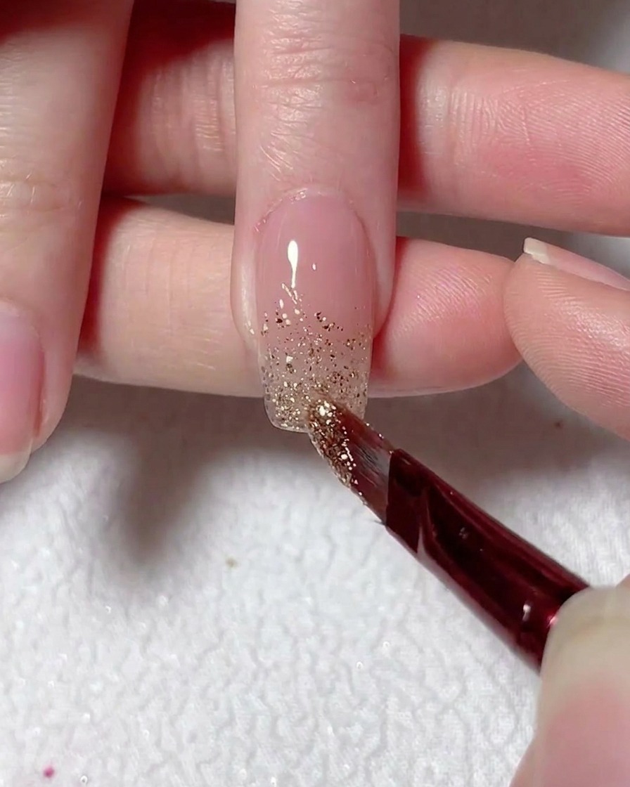 Un pennello sottile sfuma i glitter argento verso lalto dalla punta per creare un effetto ombré.
