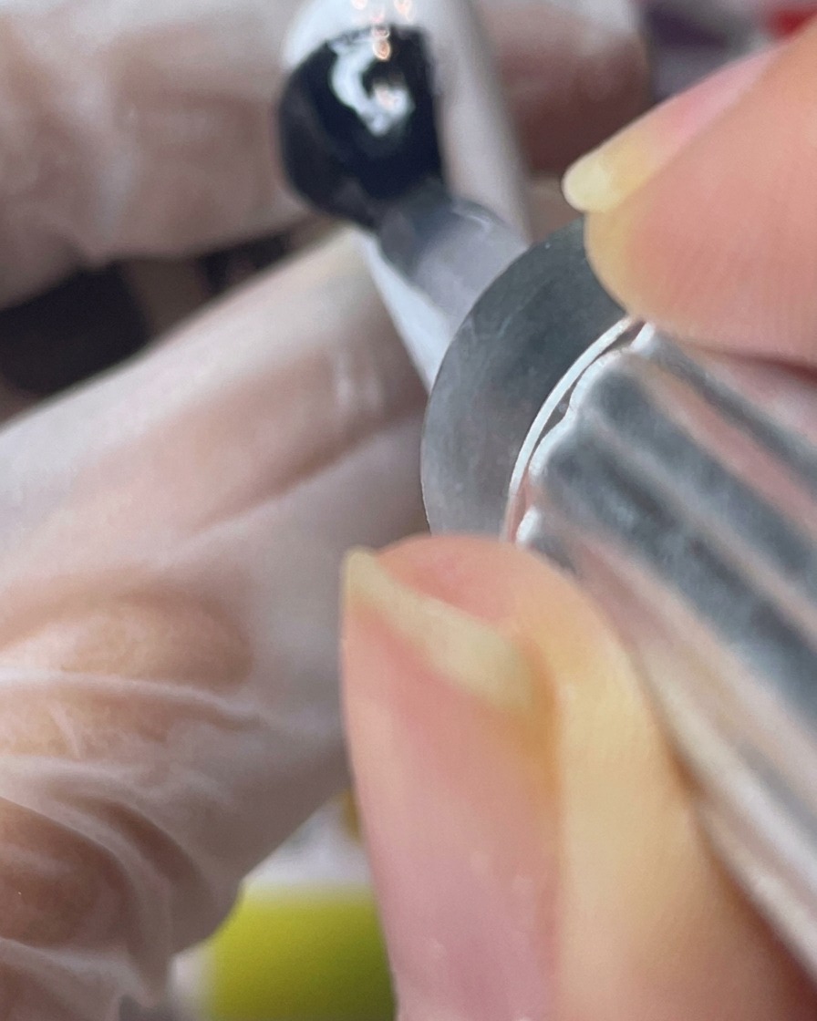 Applicazione di un top coat opaco trasparente su una tip bianca.