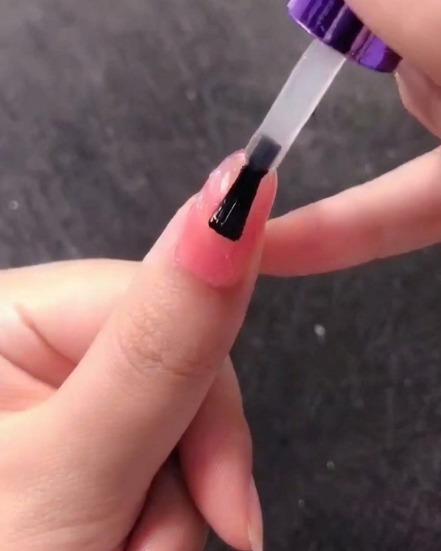 Un pennello che applica uno strato di gel trasparente sul design texturizzato a conchiglia.