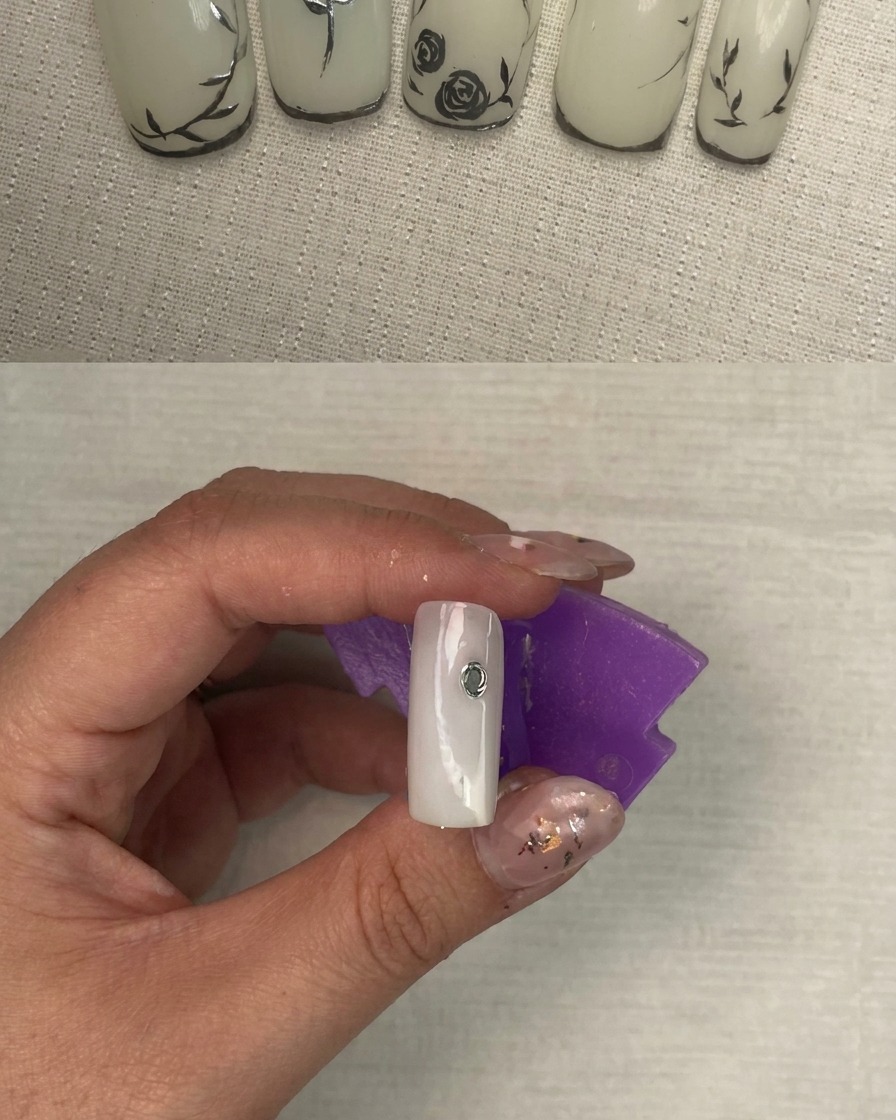 Ununghia che mostra i tratti iniziali del gel argento che formano la base di un design floreale.