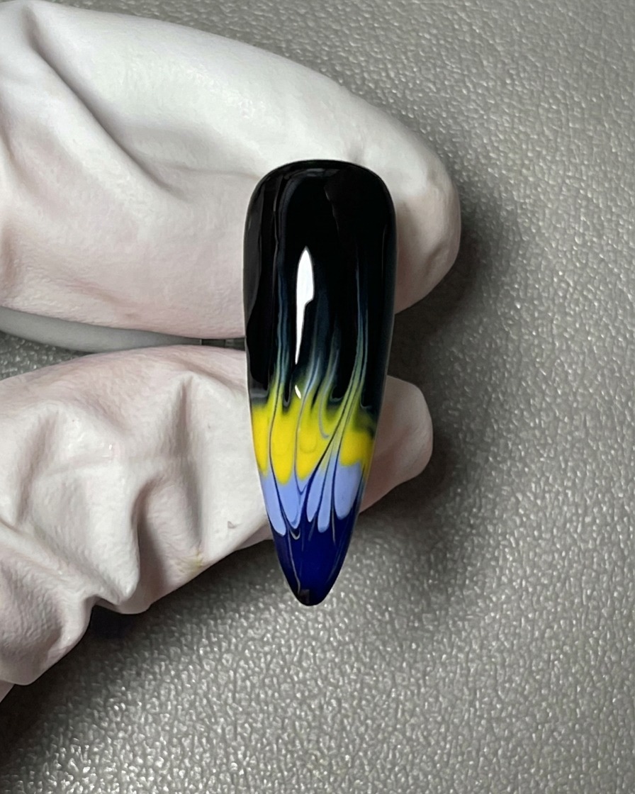 Un primo piano di ununghia ricoperta da uno smalto gel nero opaco e uniforme.