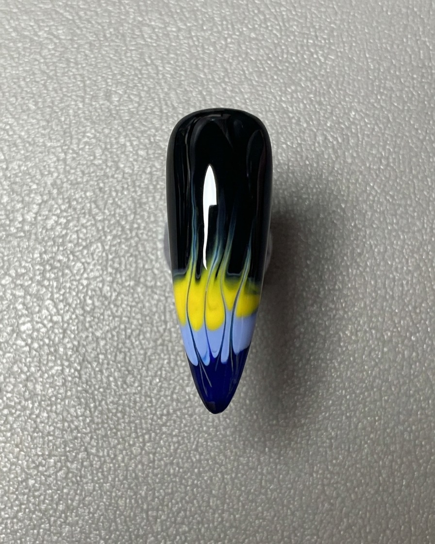 Una striscia orizzontale di smalto gel blu applicata sulla punta dellunghia rivestita di nero.