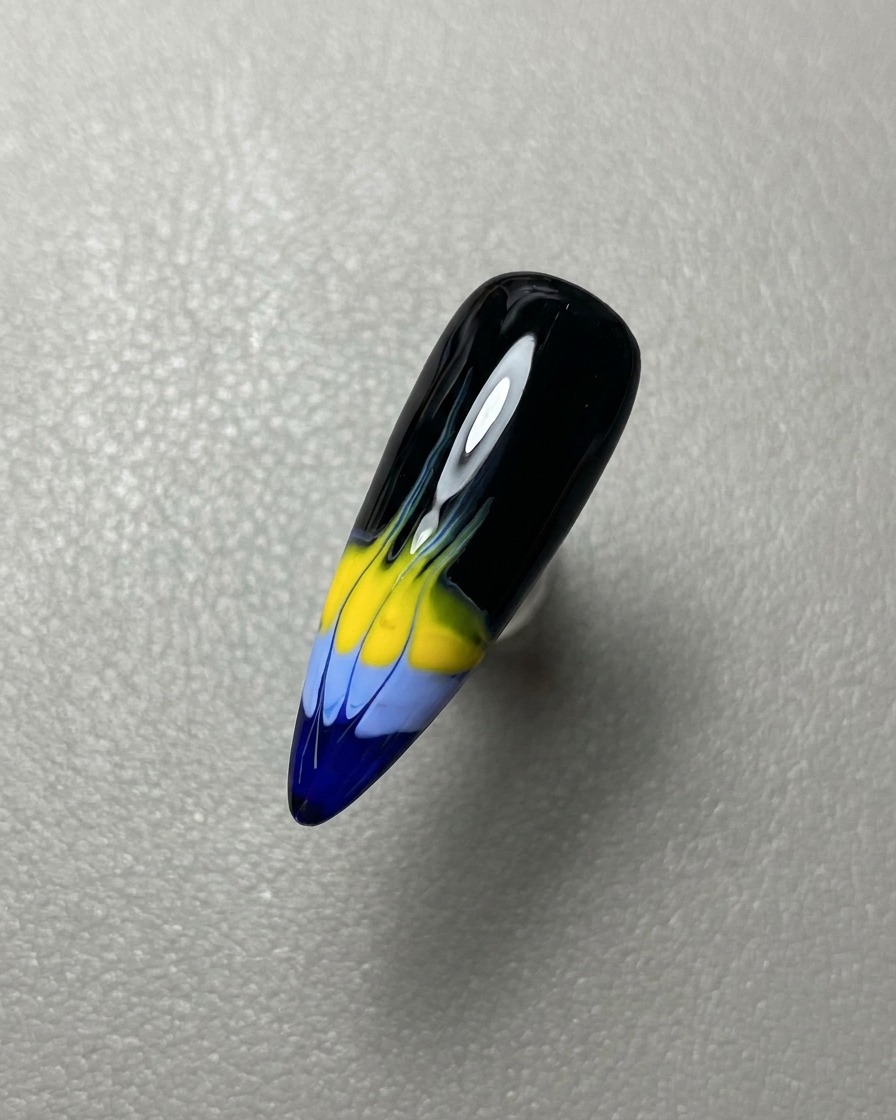Un pennello che applica uno strato di top coat gel trasparente lucido sulla nail art completata.