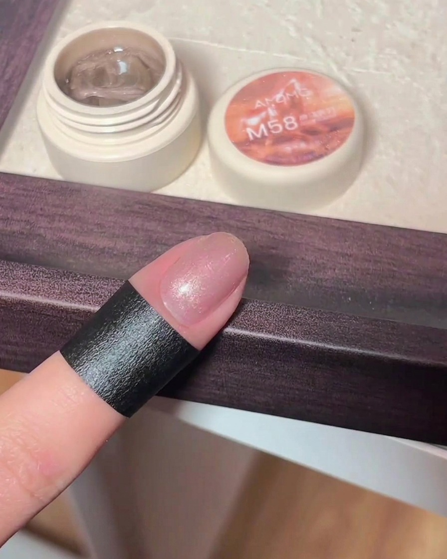 Una mano che usa un magnete sopra lunghia per creare il motivo cat-eye.