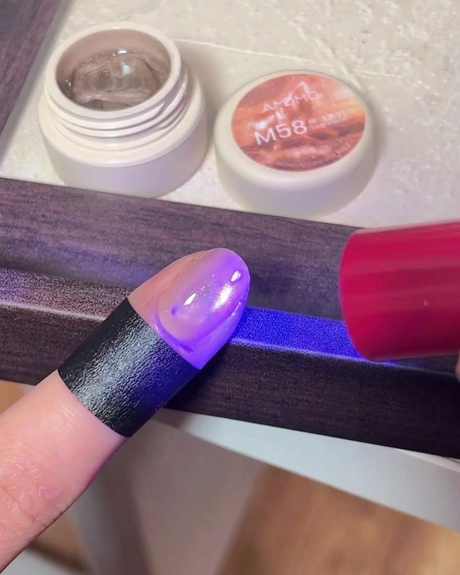 Ununghia con gel cat-eye sotto la luce UV/LED di una lampada.