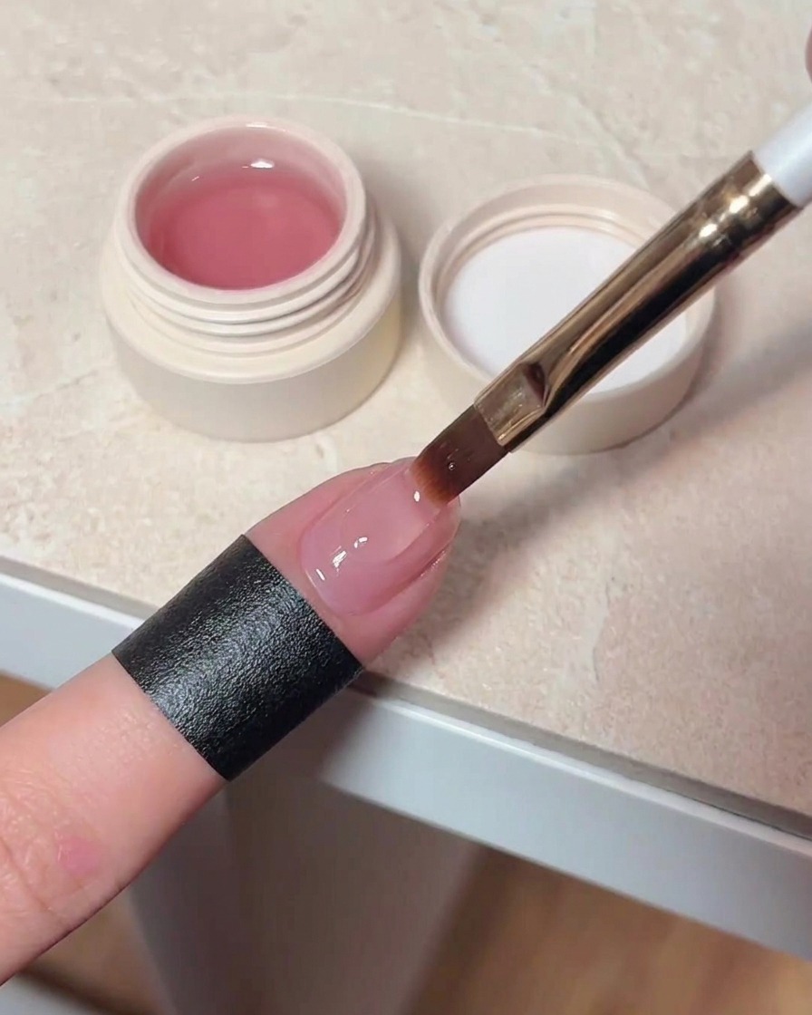 Applicazione di un top coat trasparente sopra lunghia con effetto cat-eye.
