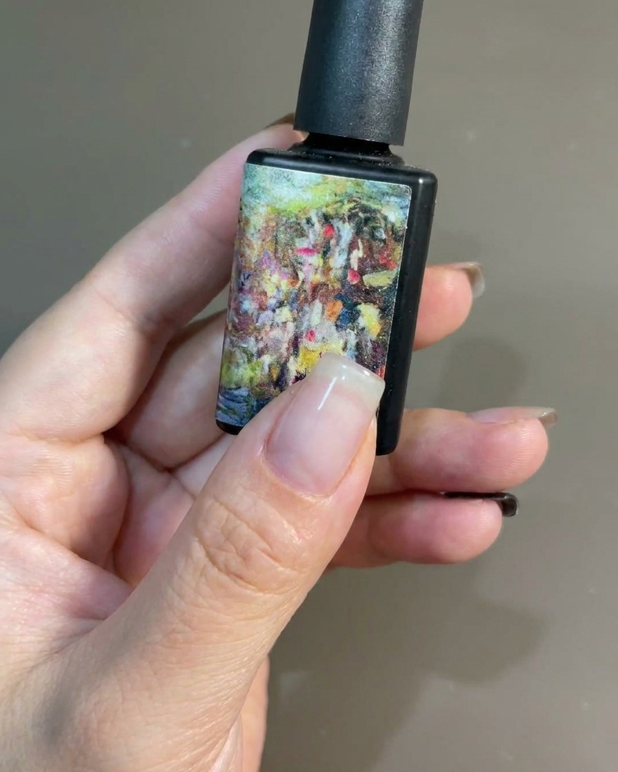 Un pennello che applica uno strato liscio di smalto gel nero su ununghia naturale.