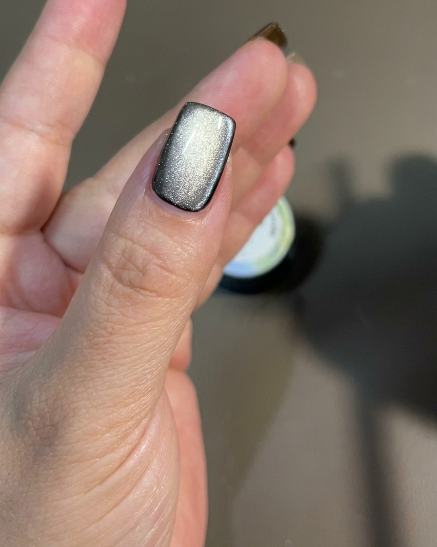 Un magnete mosso lungo la superficie dellunghia per dirigere le particelle magnetiche scintillanti.