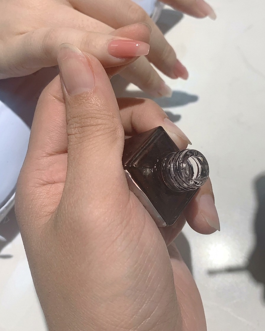 Unghie allinterno di una lampada UV che polimerizzano durante il processo di manicure.