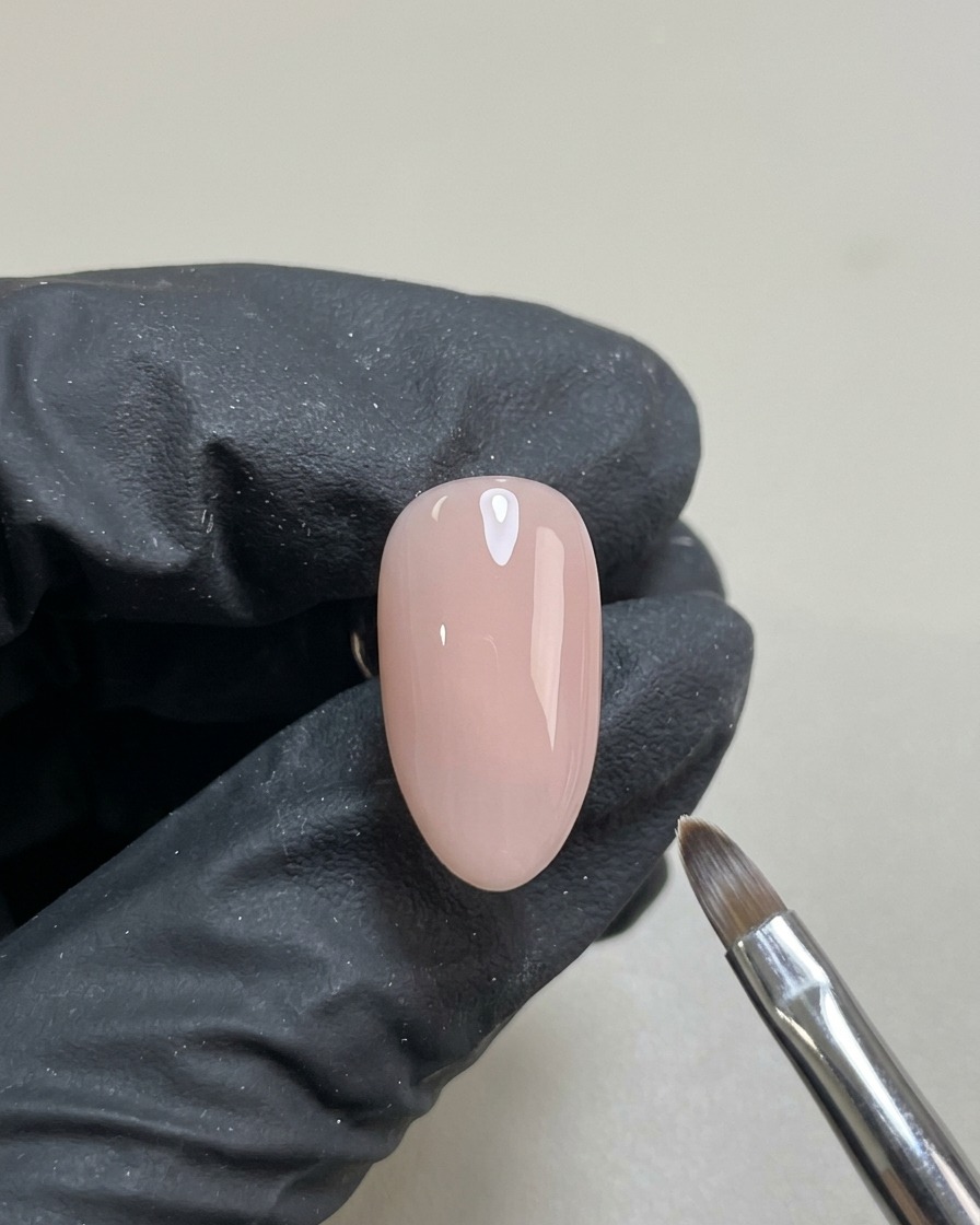 Unghia con base gel nude trasparente applicata, polimerizzata e pronta per la decorazione.