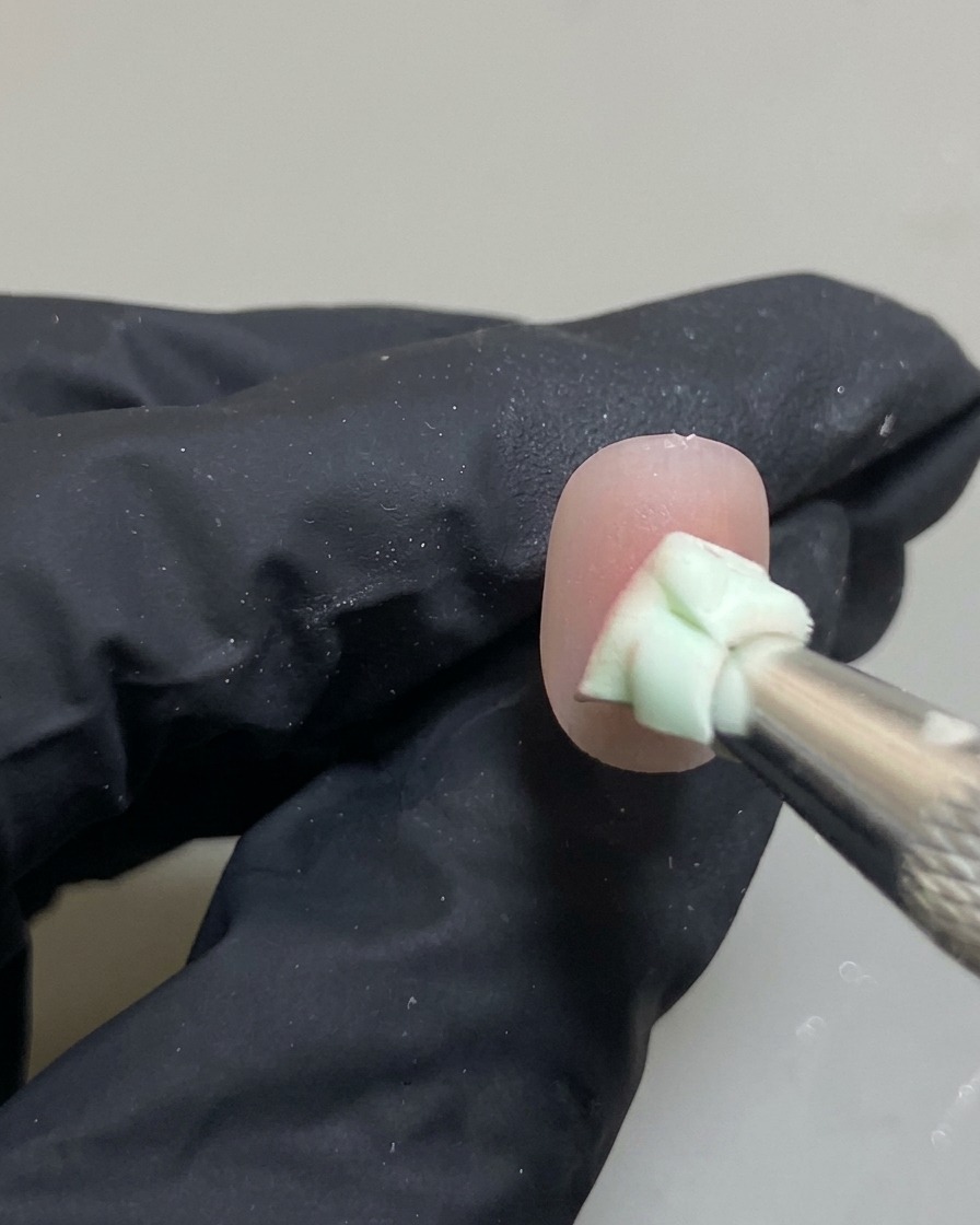 Dettaglio di ununghia con una spugna che sfuma una goccia di gel rosa per creare leffetto ombré.