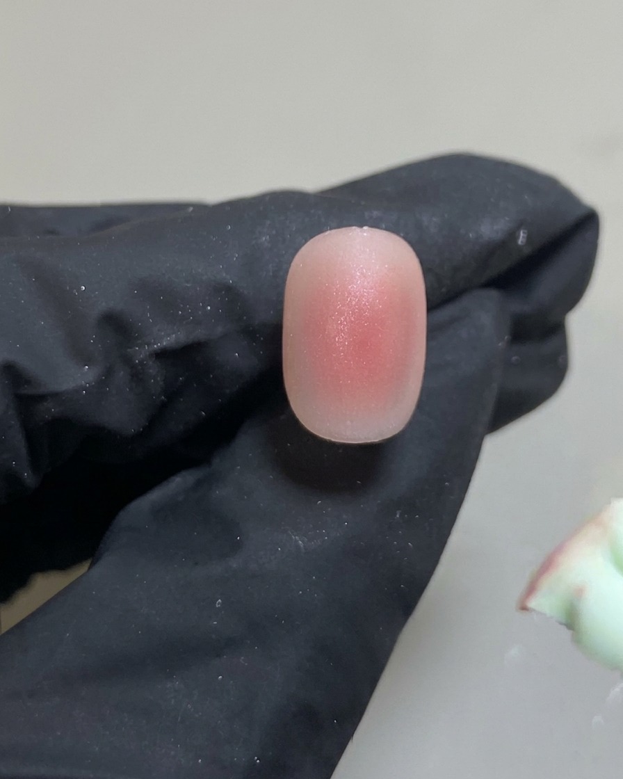 Strumento in silicone che posiziona una piccolissima goccia di gel rosa al centro dellunghia.