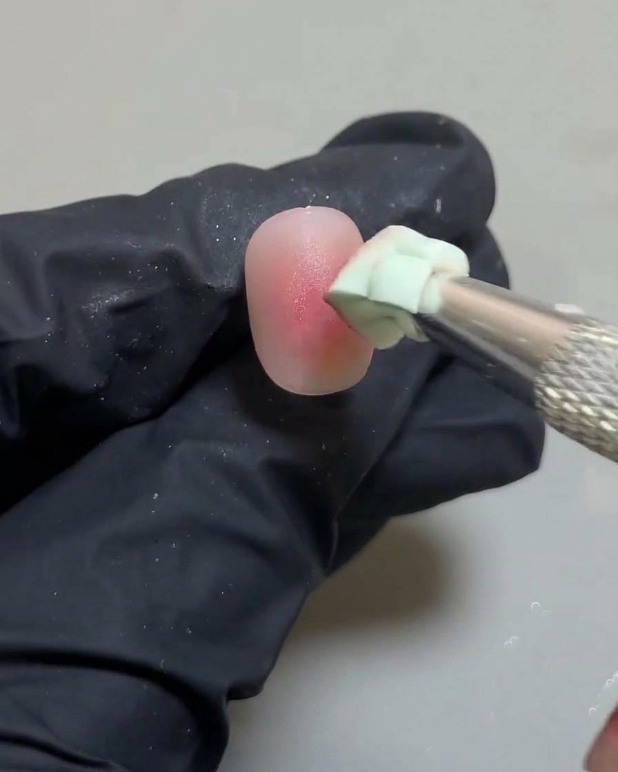 Dettaglio della spugna che perfeziona i bordi del design unghie blush.