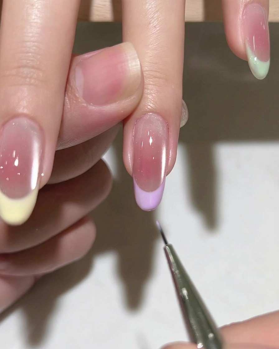Un pennello applica la base coat gel su ununghia naturale pulita e preparata.