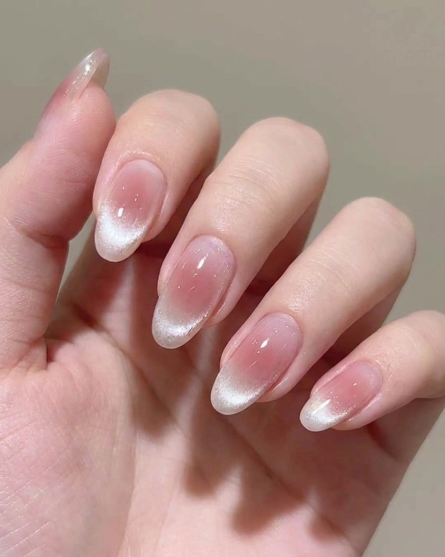Applicazione di un secondo strato di smalto gel rosa trasparente sullunghia.