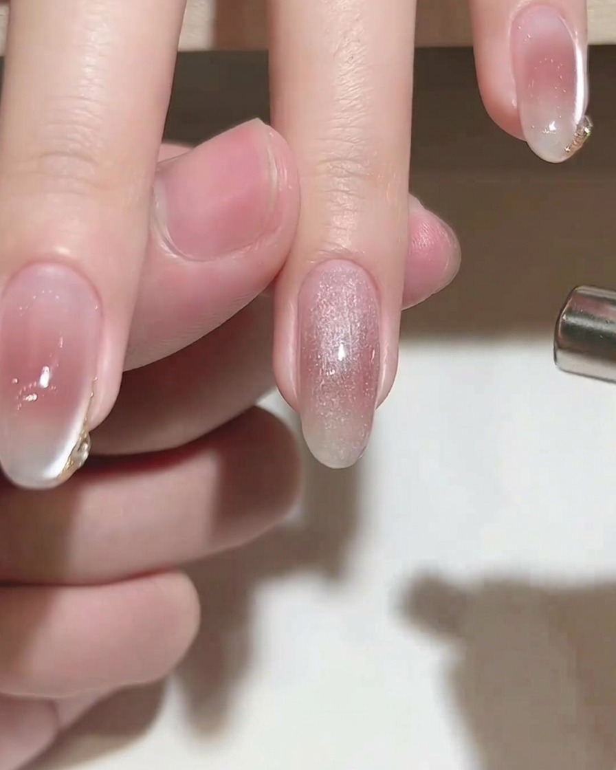 Un magnete cilindrico posizionato sopra ununghia con gel cat-eye bagnato per creare un effetto luminoso.
