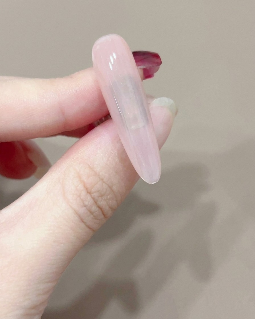 Una singola unghia polimerizzata sotto una piccola lampada UV portatile.