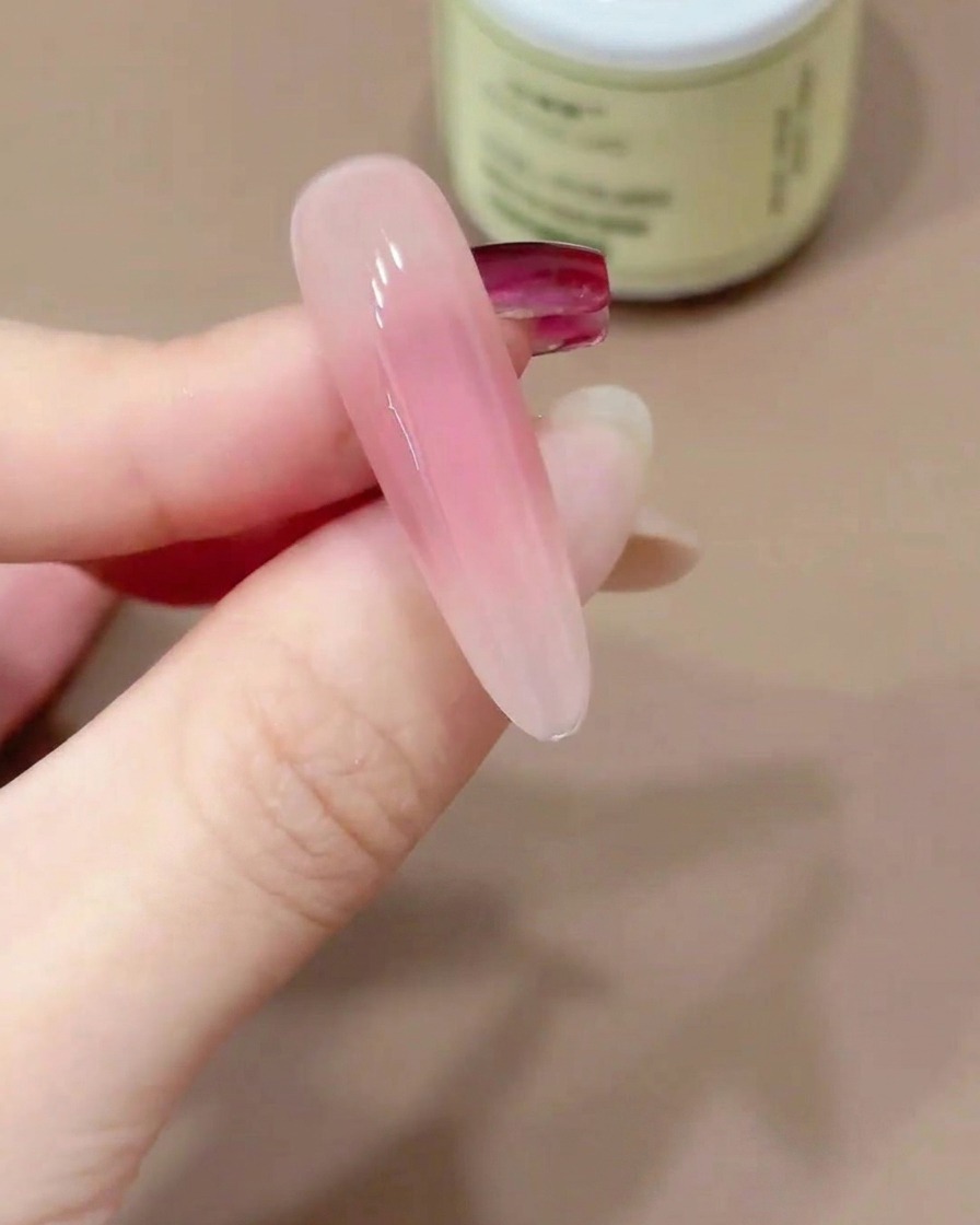 Una punta di unghia tenuta capovolta per consentire al top coat in gel di autolivellarsi.