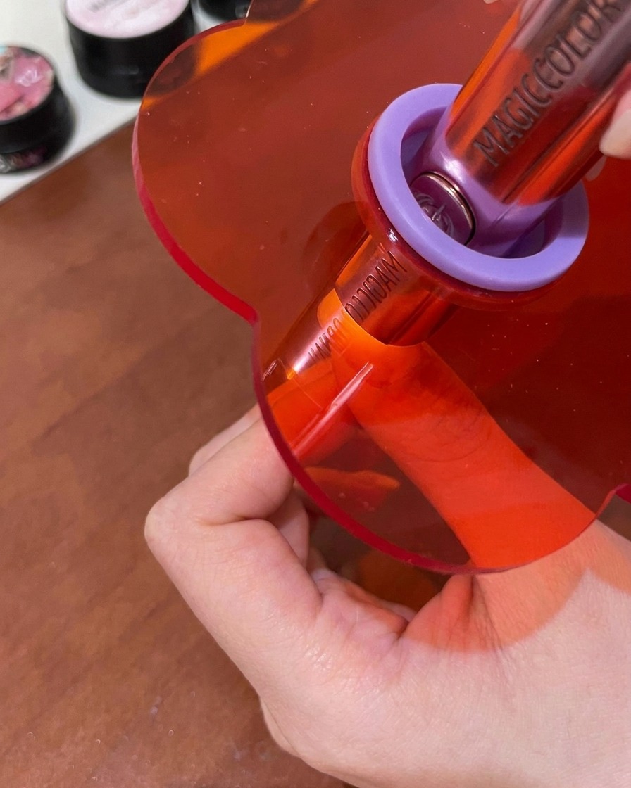 Ununghia in fase di catalizzazione sotto una piccola lampada UV/LED rosa portatile.