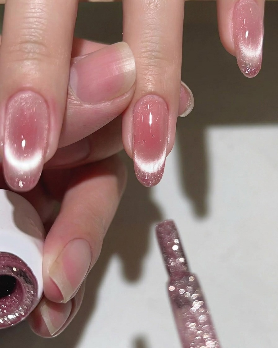 Un pennello che applica uno strato di top coat trasparente e lucido su ununghia, mostrando i dettagli glitterati e brillanti.