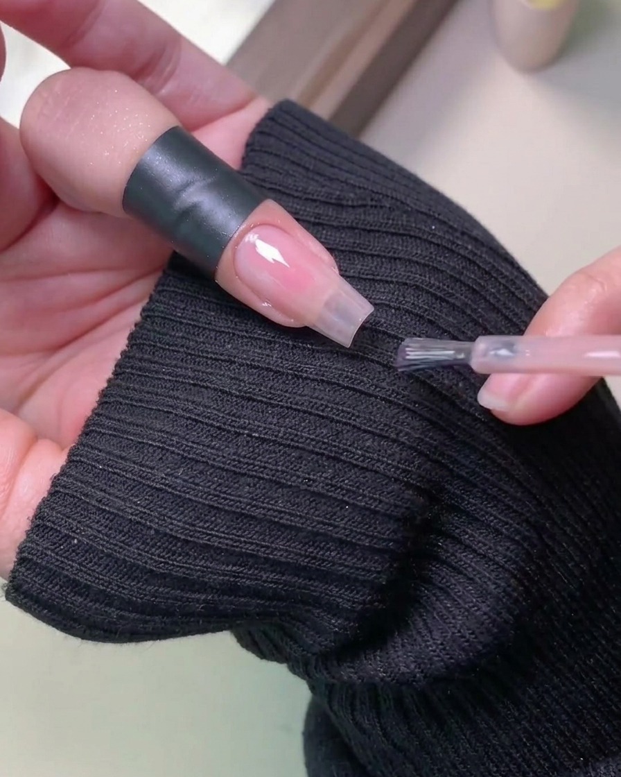 Una mano inserita in una lampada UV professionale per la catalizzazione dello smalto gel.