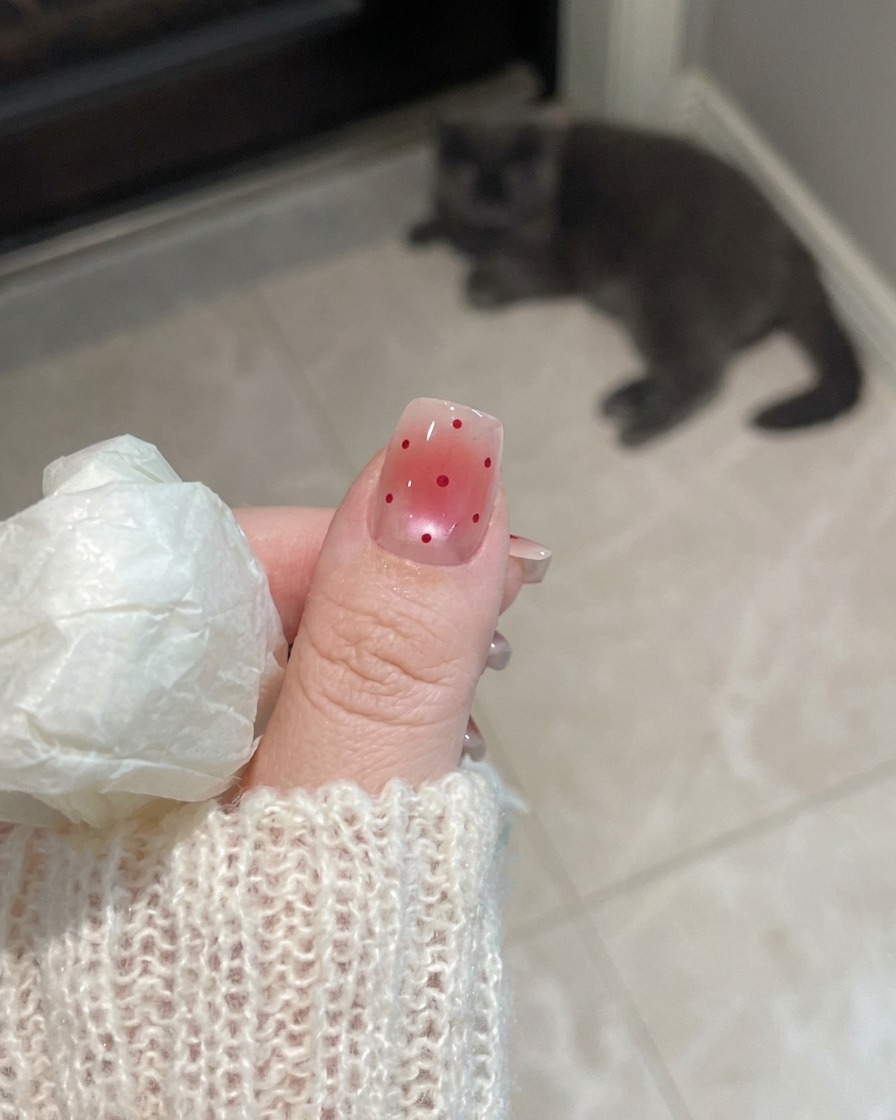Un primo piano di una mano con unghie opache che riposano sotto la luce UV di una lampada per unghie.