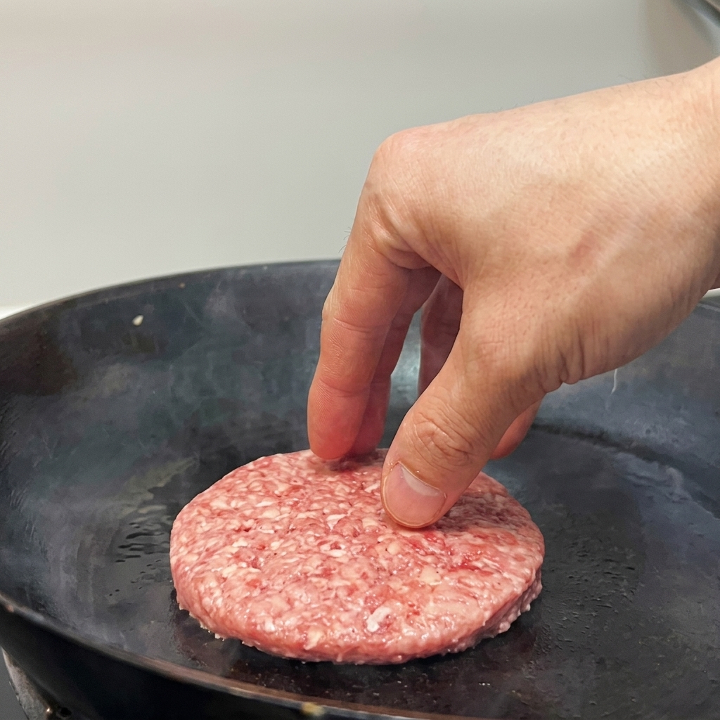 Una mano usa una spugna per applicare gel nero sulla punta dellunghia.